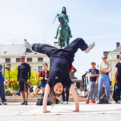 Un danseur de break, vêtu de noir, se produit avec passion dans les rues d'Orléans pour Roads Urban Festival